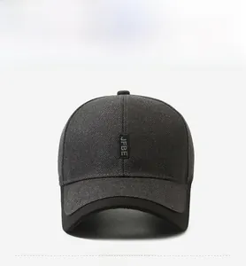 Détail d'une casquette gris foncé avec écusson logo JFBE noir et texture en maille fine