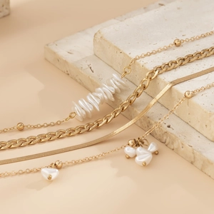 Elegant multi-layer gold snake chain necklace set with irregular white pearls and stones