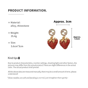Detail view of strawberry earrings with rhinestone studs and size scale 5.6x3cm