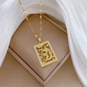Elegant gold dragon pendant necklace with crystal border on a jewelry display box