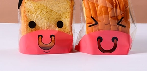 Close-up of clear plastic bread bags with cartoon cow face design holding sliced bread