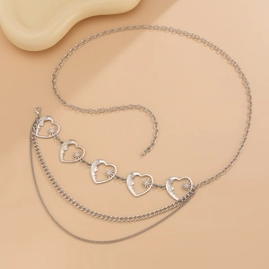 Detail of silver multi-layer chain body belt with hollow heart charms and sunburst patterns