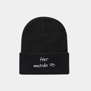 Close-up of black knit beanie with white Her weirdo embroidery and heart icons