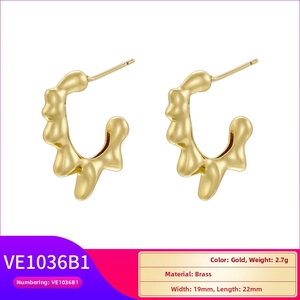 Detail view of 18K gold plated brass hoop earrings with irregular lava texture finish