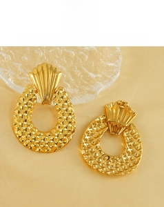 Detail view of gold shell and mesh earrings on golden silk background with glass elements