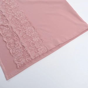 Dettaglio del tessuto rosa con bordo in pizzo floreale e cuciture di rinforzo rifinite