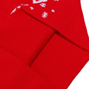 Close-up of red knitted Christmas hat fabric showing soft texture and festive patterns