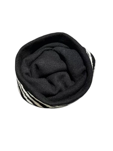 Macro shot of thick black knitted beanie with striped black and white zebra pattern trim