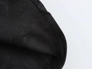Nahaufnahme der schwarzen Stofftextur und Nähte eines eleganten französischen Kleides im Detail