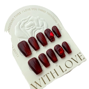 Handmade burgundy cat-eye press-on nails in coffin shape with ruby rhinestones