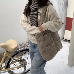 Brown felt tote bag with colorful buttoned pockets in a cozy winter snow setting