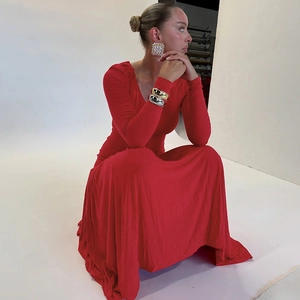 Detail view of red V-neck maxi dress fabric and stylish chunky gold and silver bangles