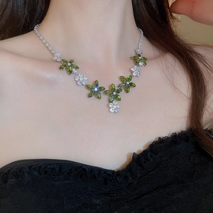 Gros plan du collier en argent avec pendentifs fleurs en zircon vert sur un mannequin