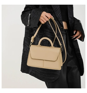 Chic beige PU leather square handbag with top handle and strap styled on a fashion model