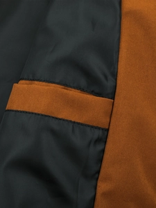 Detailopname van dubbele stiksels op grijze en oranje jasstof met fijne textuur