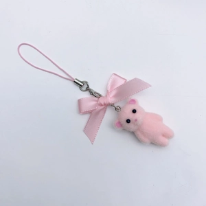 Detailed view of a pink flocked bear keychain with ribbon bow and beaded lanyard