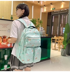 Detail of light green multi-pocket school bag with cute bear and cherry floral print