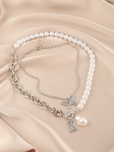 Detailed view of multilayer pearl necklace with butterfly pendant and OT clasp