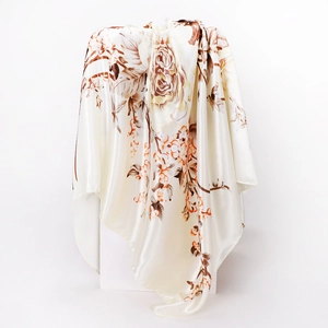 Close-up of elegant floral silk scarf with rose patterns on ivory satin fabric