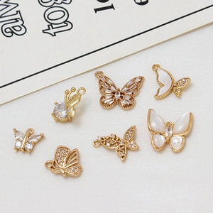 Macro shot of gold-plated butterfly charms with cubic zirconia and mother of pearl