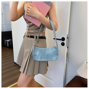 Détail du sac à bandoulière en cuir PU bleu clair avec texture effet vieilli et sangle