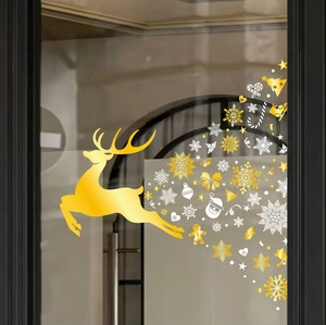Detail of golden reindeer and white snowflake Christmas window stickers on glass