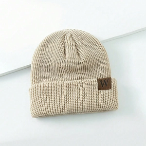 Knitted winter beanie for kids in beige with ribbed texture and brown leather W patch
