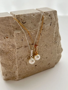 Close-up of S925 sterling silver pearl necklace set with shimmering diamond accents