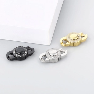Three crystal-encrusted stainless steel jewelry clasps in black, silver, and gold finishes