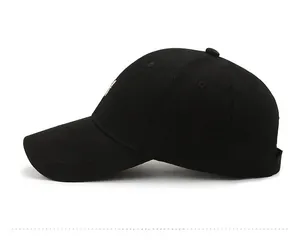 Side view of black cotton baseball cap featuring gold letter H embroidery and curved brim
