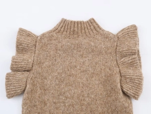 Détail d'une robe en maille camel avec col roulé et volants élégants sur les manches