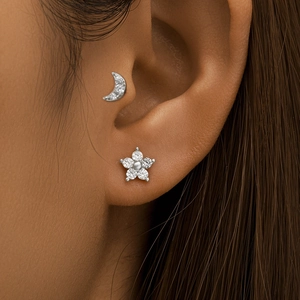 Close-up of S925 silver crescent moon and pearl flower cartilage studs on a model