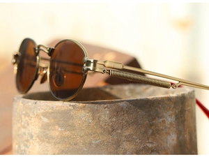 Detail of vintage steampunk sunglasses showing copper metal frame and spring hinge design