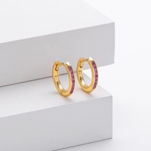 Detail of gold hoop earrings with inset pink zircon stones on a white geometric stand