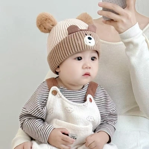 Detail of warm baby winter knit hat with cute bear ears and plush fleece overalls