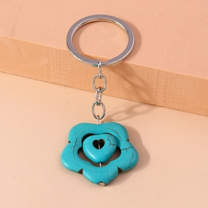 Ethnic style flower keychain with turquoise heart and silver ring on geometric background
