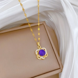 Macro shot of a gold titanium necklace featuring a purple stone with diamond accents