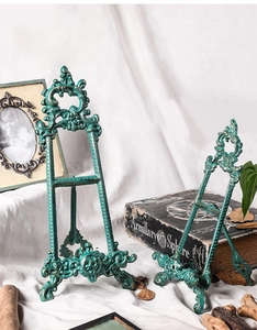 Vista detallada de soportes vintage de hierro turquesa con tallas barrocas ornamentadas