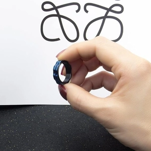 Detail of dark blue 6mm spinning gear ring held by hand to show rotating texture