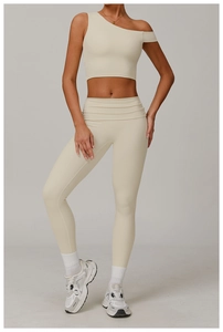 Détail du haut de yoga beige à une épaule et du legging taille haute en tissu