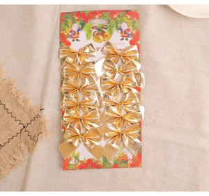 Close-up of 12 sparkling gold Christmas tree bow ornaments on festive cardboard packaging