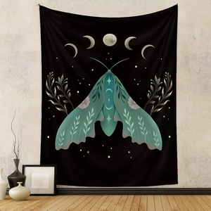 Detail of bohemian black wall tapestry featuring green moth, moon phases and plant patterns