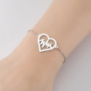 Close-up of heart-shaped heartbeat bracelet on wrist in polished silver finish