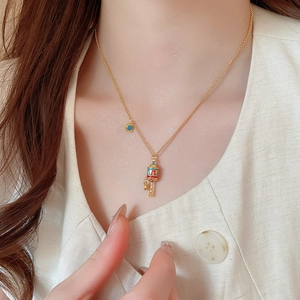 Detail of gold hollow flower pendant necklace with colorful enamel on a female model