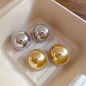 Detailed view of gold and silver dome earrings with a ring of sparkling crystals