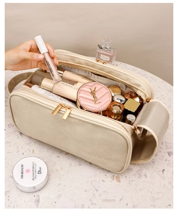 Detail of beige PU leather toiletry bag with gold zippers and embossed GOOD LUCK text