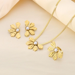 Close-up of 18K gold floral jewelry set with white pearls and flat snake chain