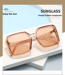 Detail of square amber sunglasses featuring gold metal accents and polarized lenses