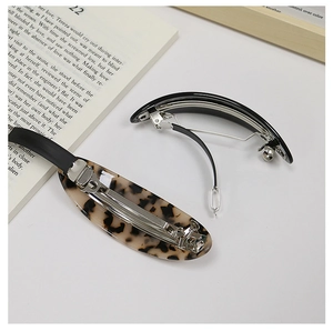 Close-up of tortoise shell and black acetate hair clips with silver metal spring clips