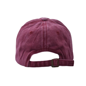 Détail de la boucle métallique réglable et de la texture du tissu bordeaux délavé sur la casquette